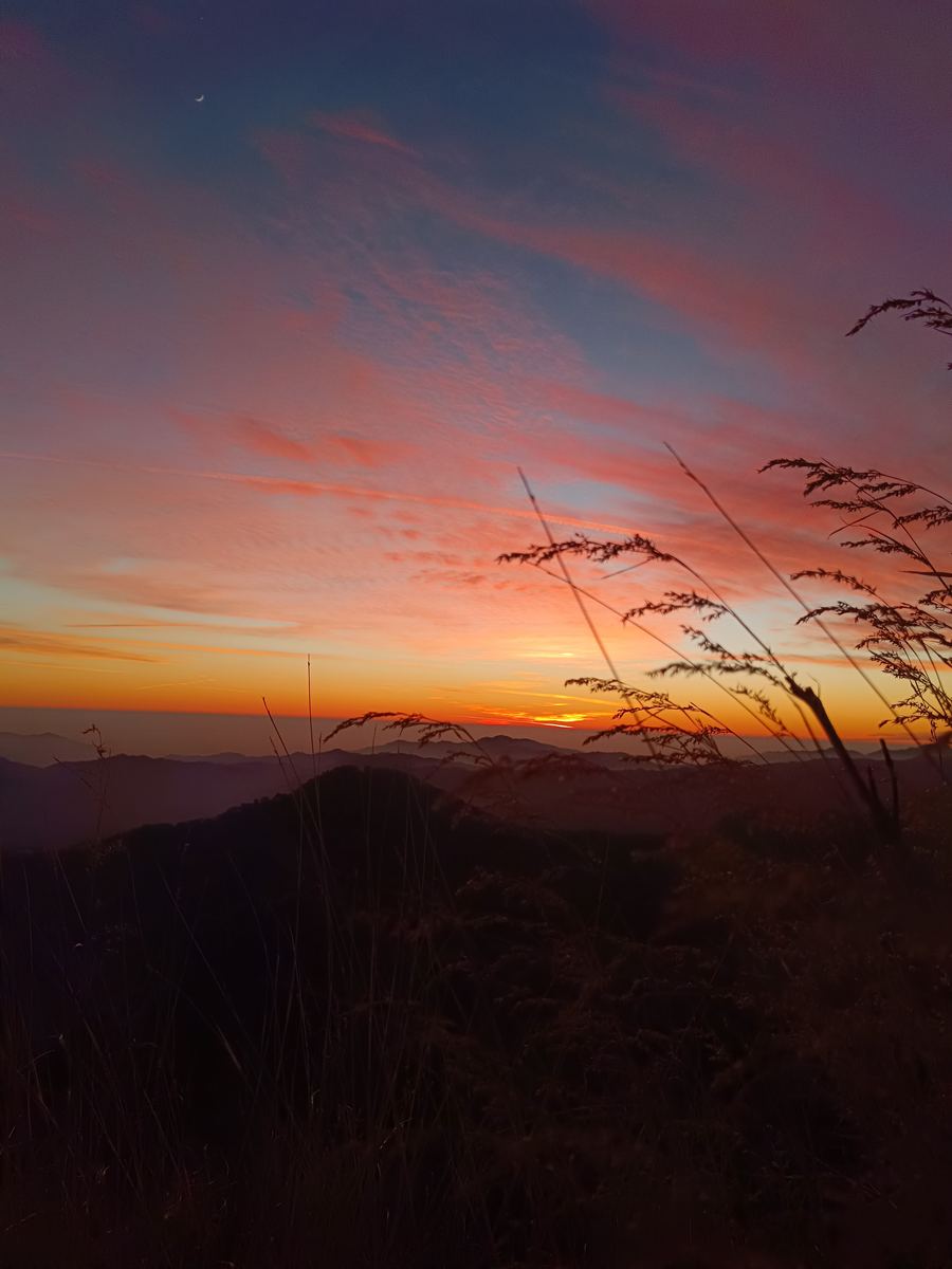 A crescent moon over sunset hills from the fort ridge