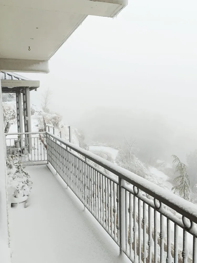 Fresh snow piled on the balcony railings the morning after a snowfall