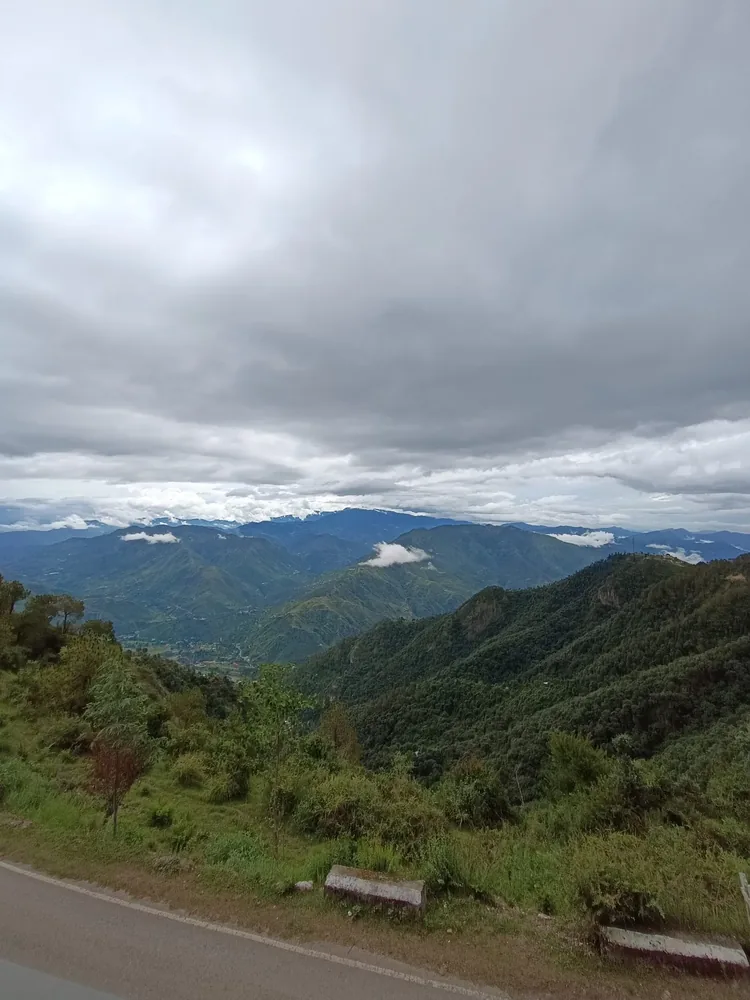 Monsoon view from the ridge — low clouds over the Himachal valley and green forested ridges