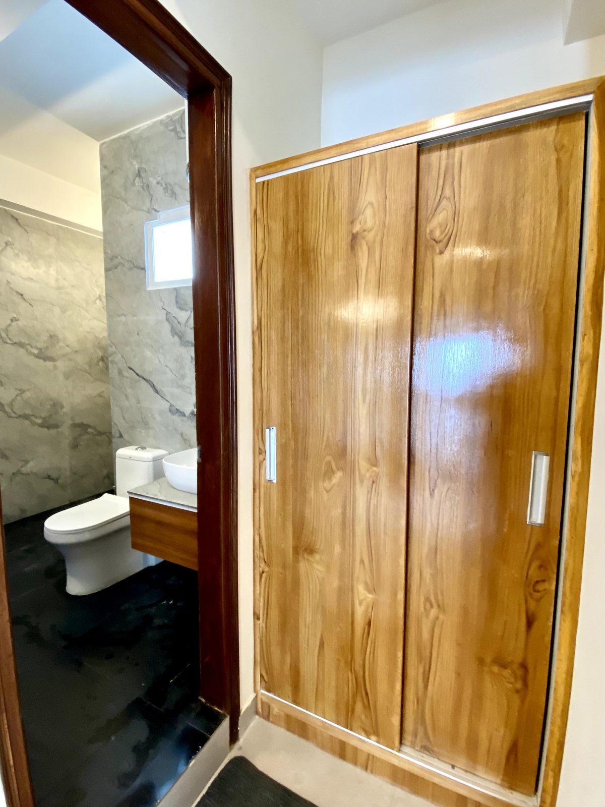Wooden sliding-door wardrobe beside the en-suite bathroom doorway