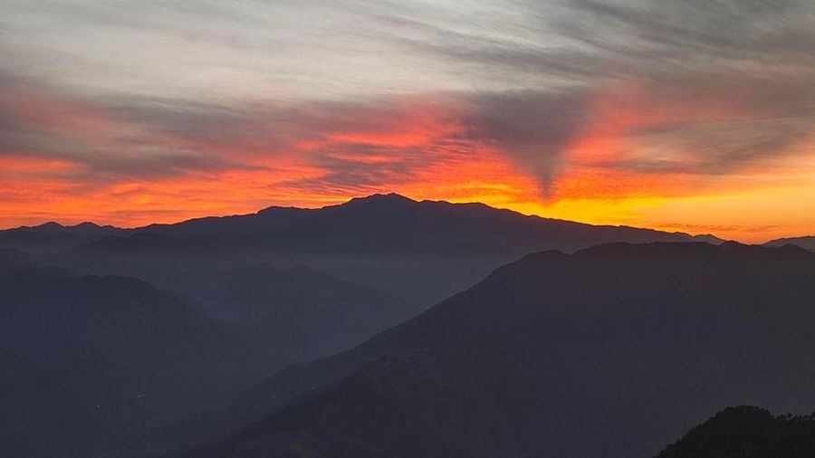 Sunset godrays through layered Himachal ranges